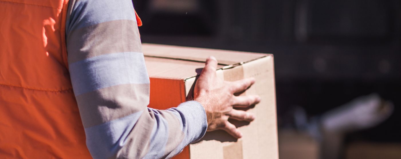 Trabajador cargando una caja de cartón